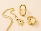 Set de joyas doradas en acero inoxidable con collar de ojo turco y anillos modernos ajustables
